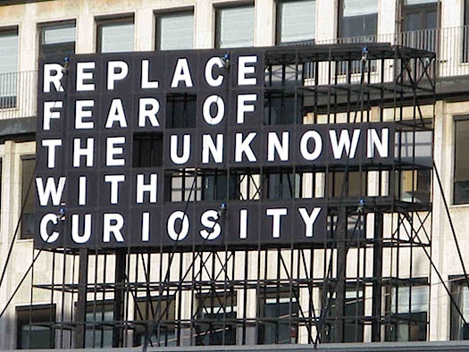 outdoor sign 'replace fear of the unknown with curiosity'